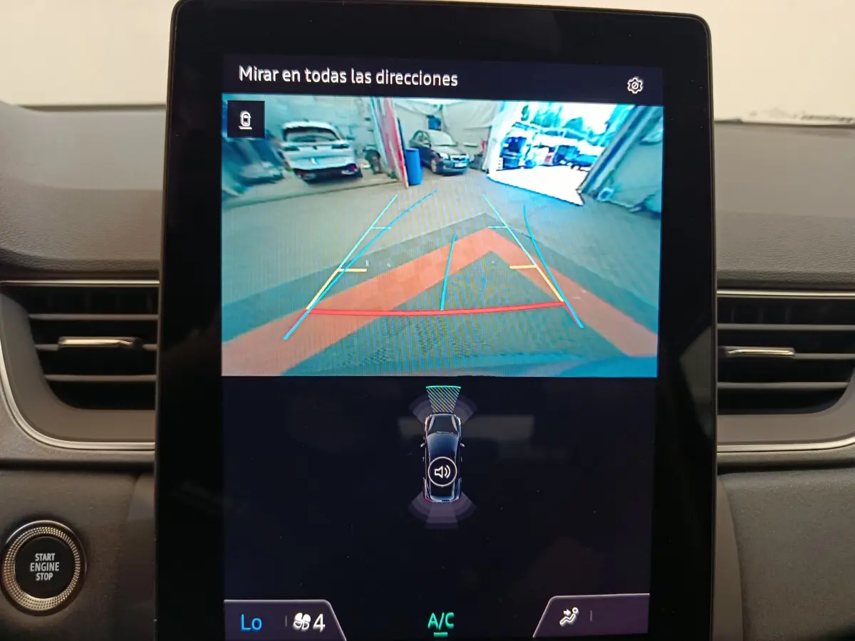 Écran tactile central montrant la caméra de recul et l'aide au stationnement du Renault Captur gris foncé 2025.