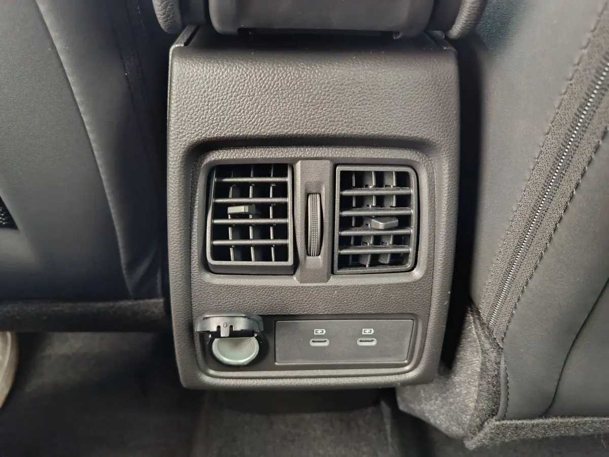 Vue rapprochée des aérateurs arrière et ports USB du Renault Captur Techno Eco-G gris foncé, intérieur noir.