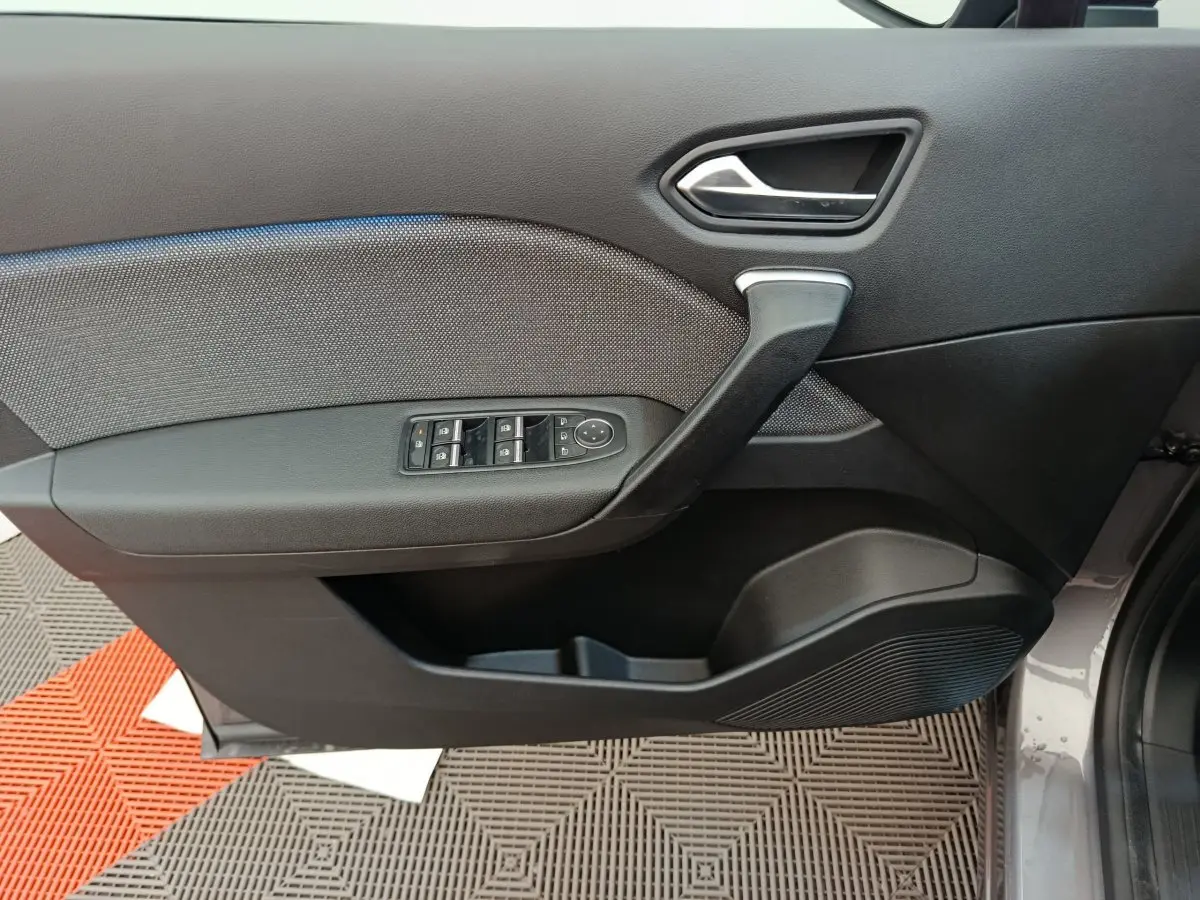 Porte côté gauche du Renault Captur 2025 gris foncé, avec commandes électriques des vitres et poignée intégrée.