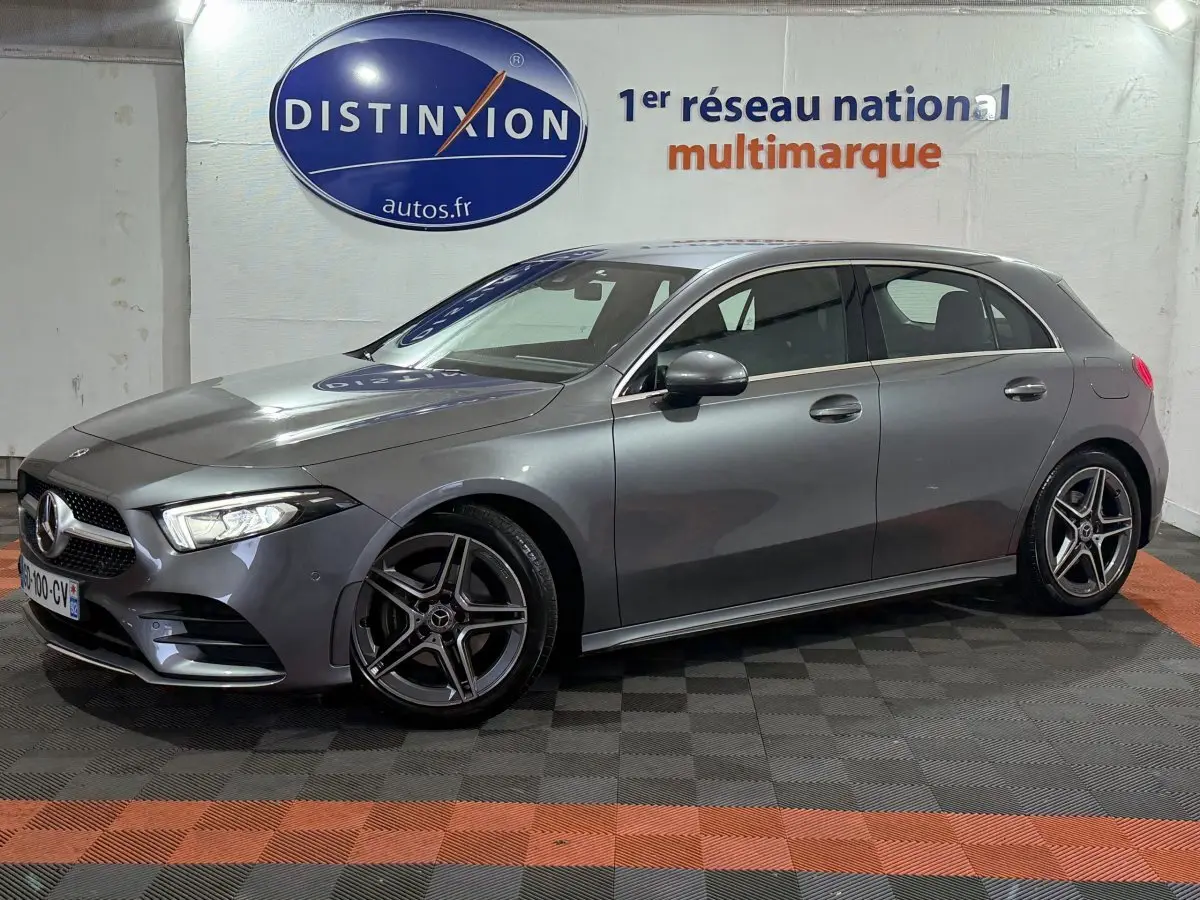 Mercedes Classe A 200 AMG Line gris foncé vue de profil côté gauche dans un showroom avec logo Distinxion en arrière-plan.