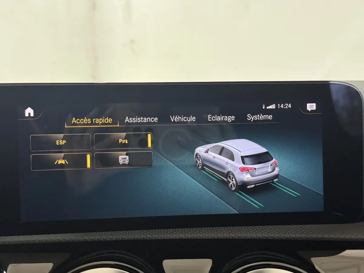 Écran tactile intérieur montrant l'interface d'assistance avec une Mercedes Classe A grise vue en 3/4 arrière.