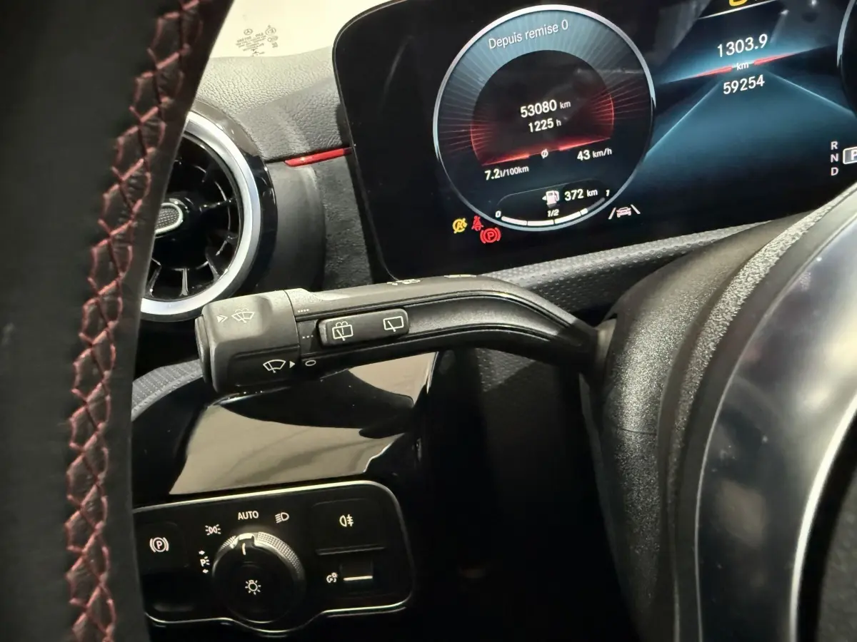 Gros plan sur le tableau de bord numérique et la commande des essuie-glaces de la Mercedes Classe A gris foncé, version AMG Line.