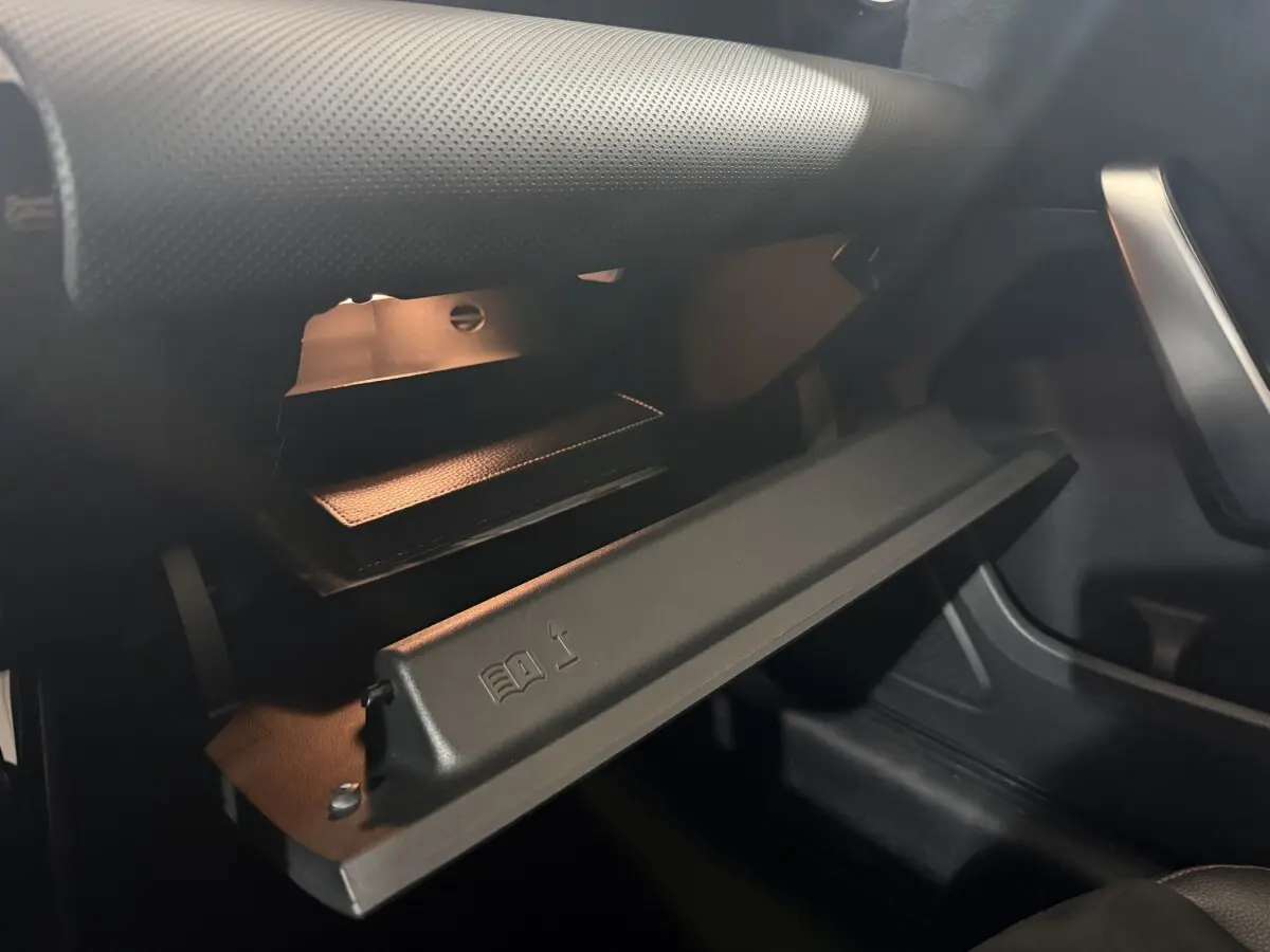 Vue rapprochée de la boîte à gants ouverte côté passager du Mercedes Classe A A 200 AMG Line gris foncé, intérieur noir.