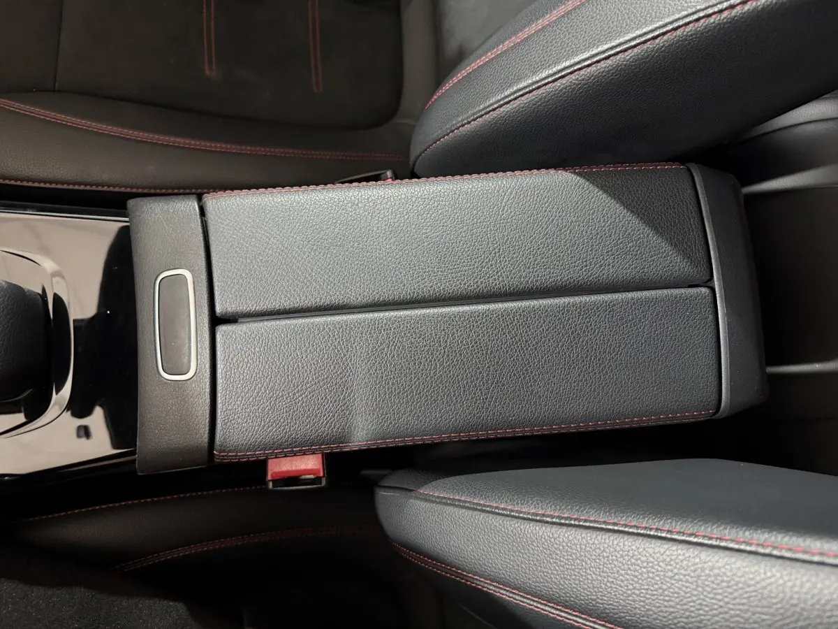 Vue rapprochée de l'accoudoir central en cuir noir avec surpiqûres rouges dans une Mercedes Classe A A 200 AMG Line 2021.