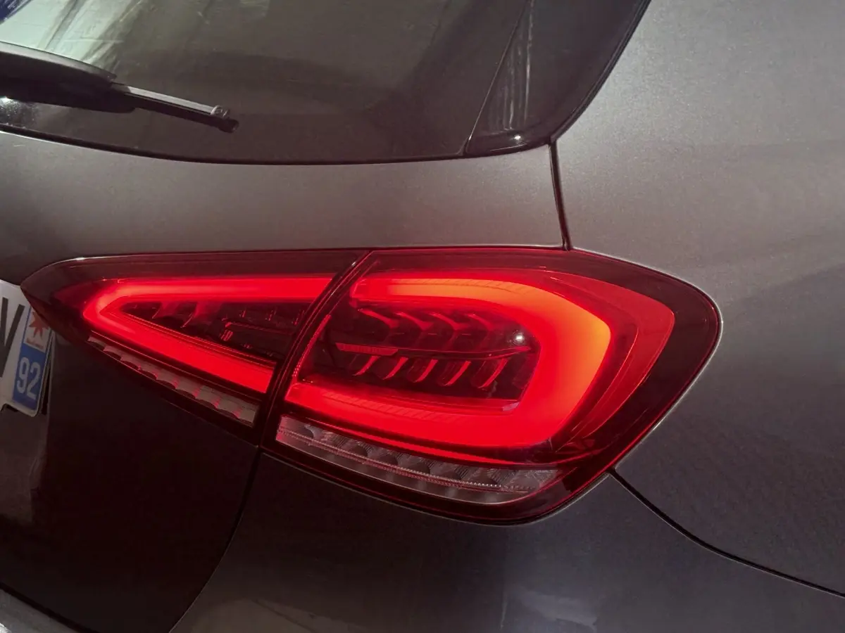 Gros plan sur le feu arrière droit rouge d’une Mercedes Classe A 200 AMG Line gris foncé, vue de l’arrière.