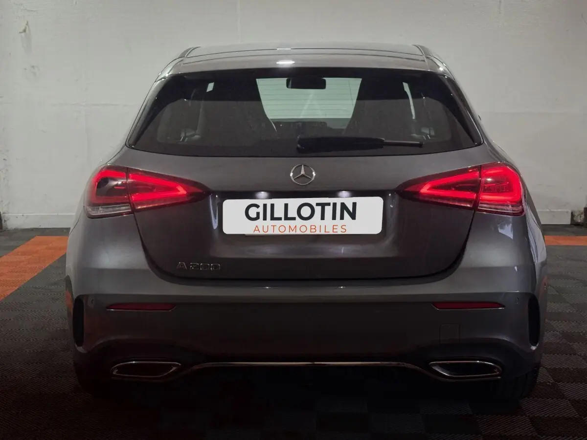 Vue arrière d'une Mercedes Classe A 200 AMG Line gris foncé avec feux LED allumés dans un garage.