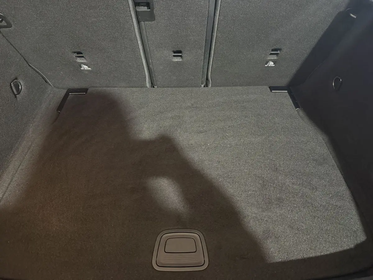 Vue plongeante sur le coffre spacieux et tapissé de moquette noire d'une Mercedes Classe A A 200 AMG Line 2021.