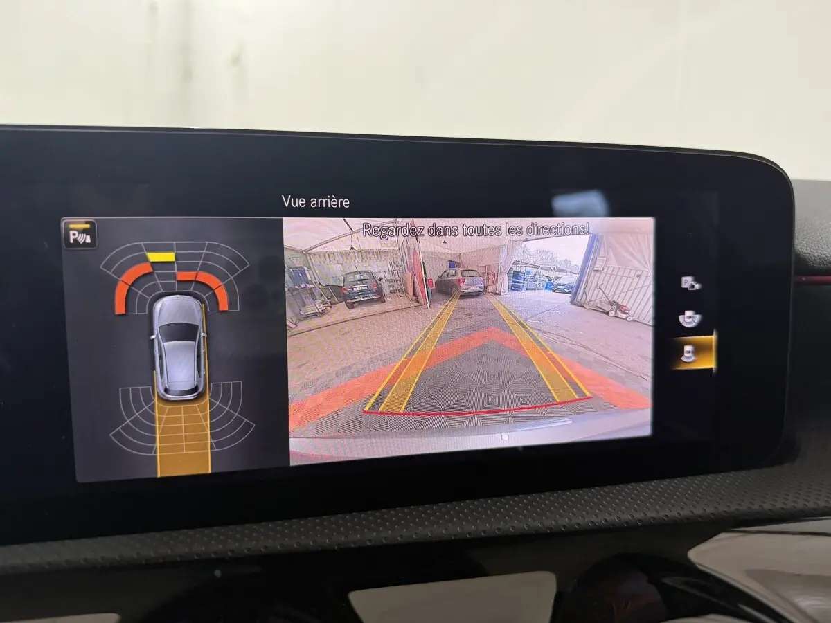 Écran tactile intérieur montrant la caméra de recul et l’aide au stationnement de la Mercedes Classe A A 200 AMG Line gris foncé.