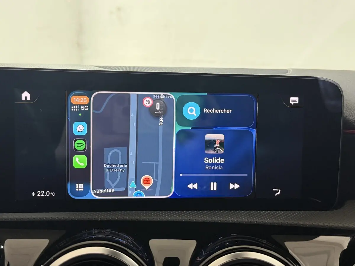 Écran tactile central de la Mercedes Classe A 200 AMG Line 2021 affichant navigation et musique, vue intérieure frontale.