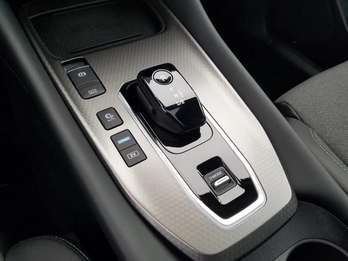 Gros plan sur la console centrale du Nissan Qashqai 1.5 E-POWER 2025 avec levier de boîte auto et boutons de contrôle.