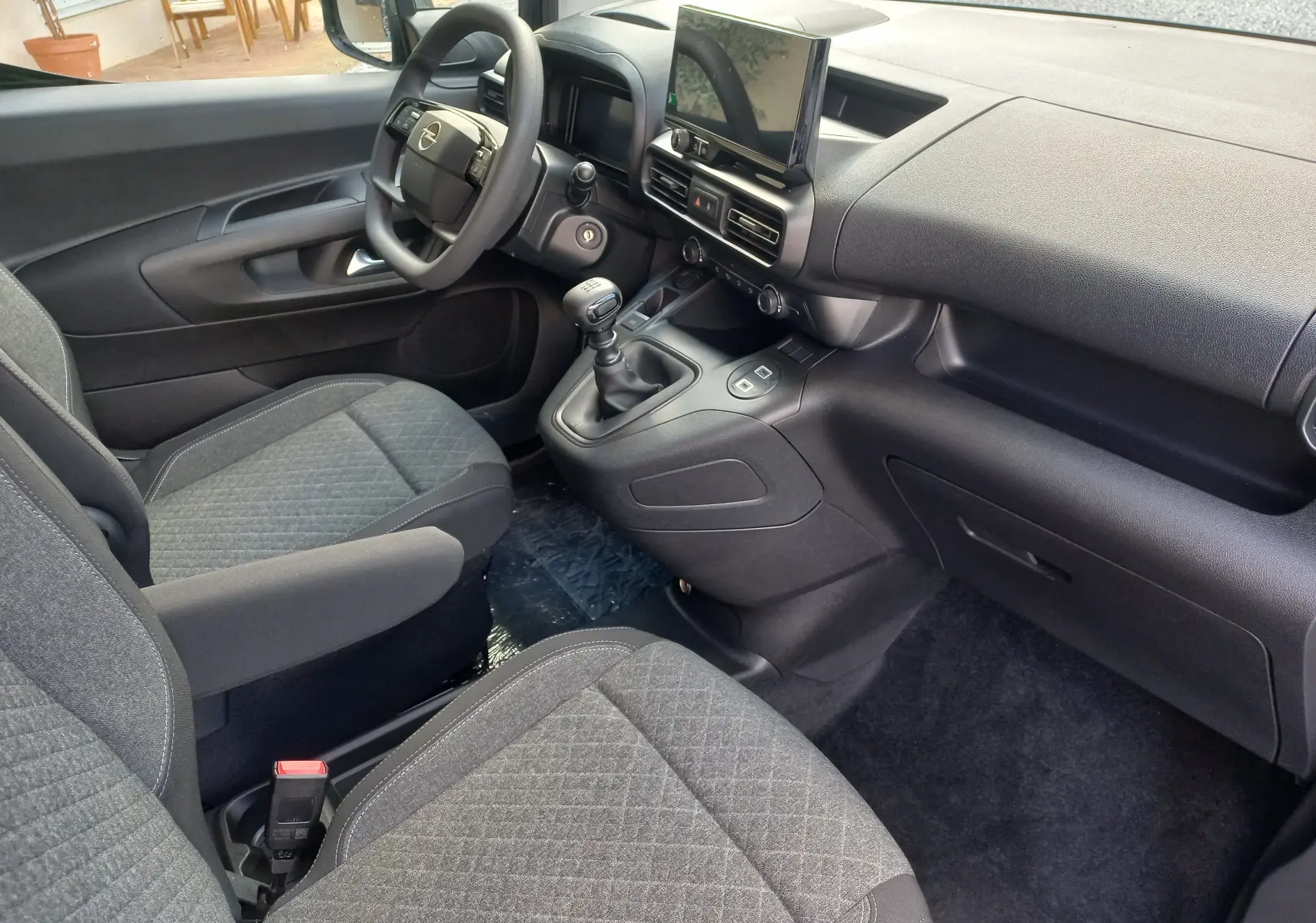 Vue intérieure côté conducteur de l’Opel Combo Life 2025 avec tableau de bord noir et écran tactile central.