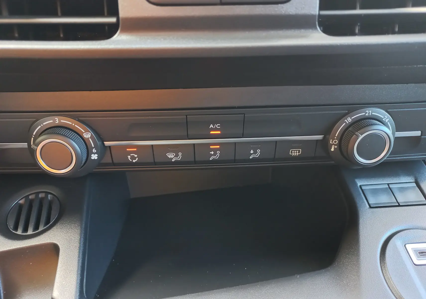 Vue rapprochée de la console centrale de l’Opel Combo Life 2025, montrant les commandes de climatisation et ventilation.