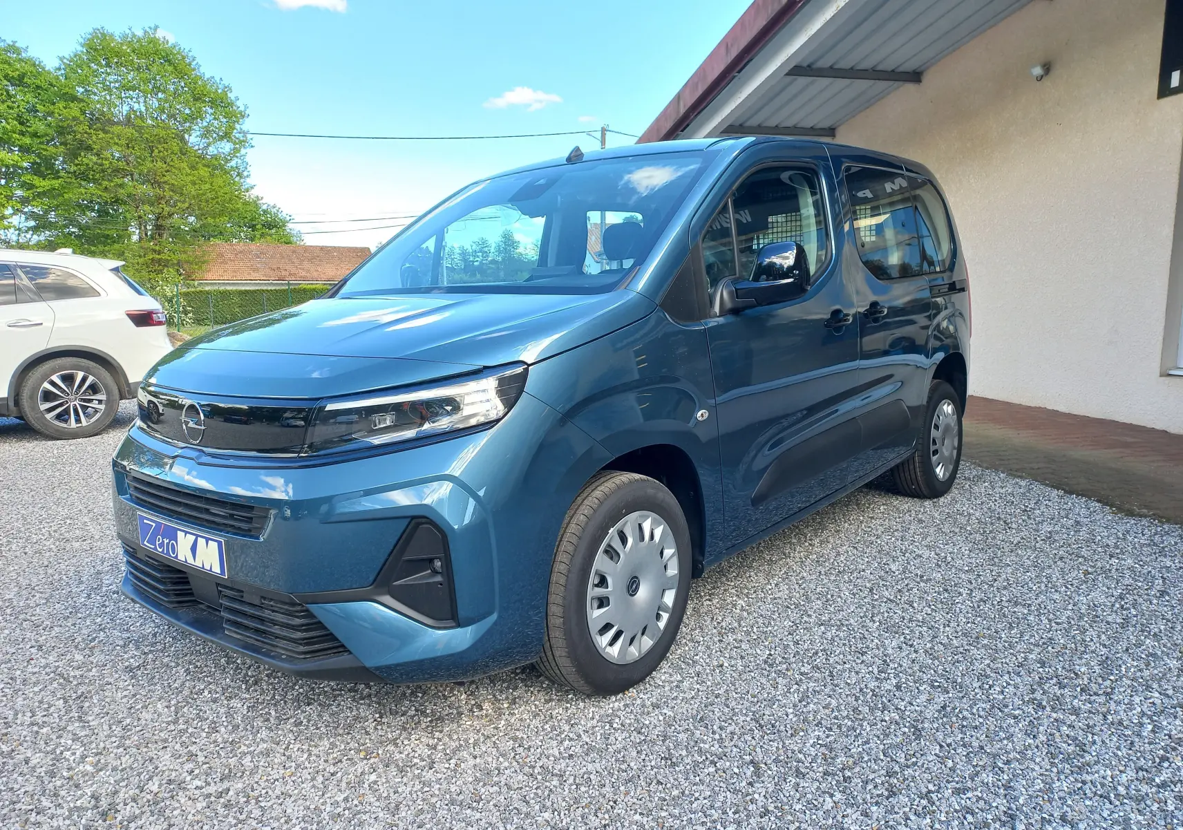 Vue 3/4 avant droite d'un Opel Combo Life bleu Kiama 2025 avec calandre noire et jantes acier.