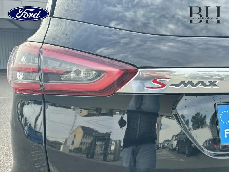 Gros plan sur le feu arrière gauche et le logo S-MAX chromé d’un Ford S-MAX noir mica Shadow, vue arrière côté gauche.
