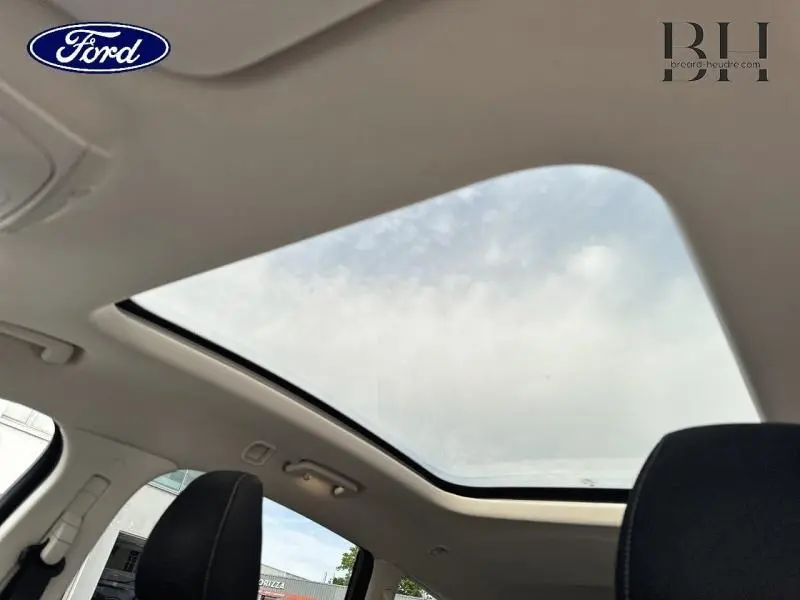 Toit panoramique en verre du Ford S-MAX 2018, vue intérieure montrant ciel et sièges noirs.