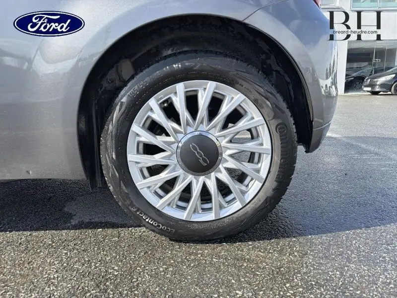 Gros plan sur la roue avant droite d'une FIAT 500 Electroclash Grey Métal avec jante alu au design étoilé.