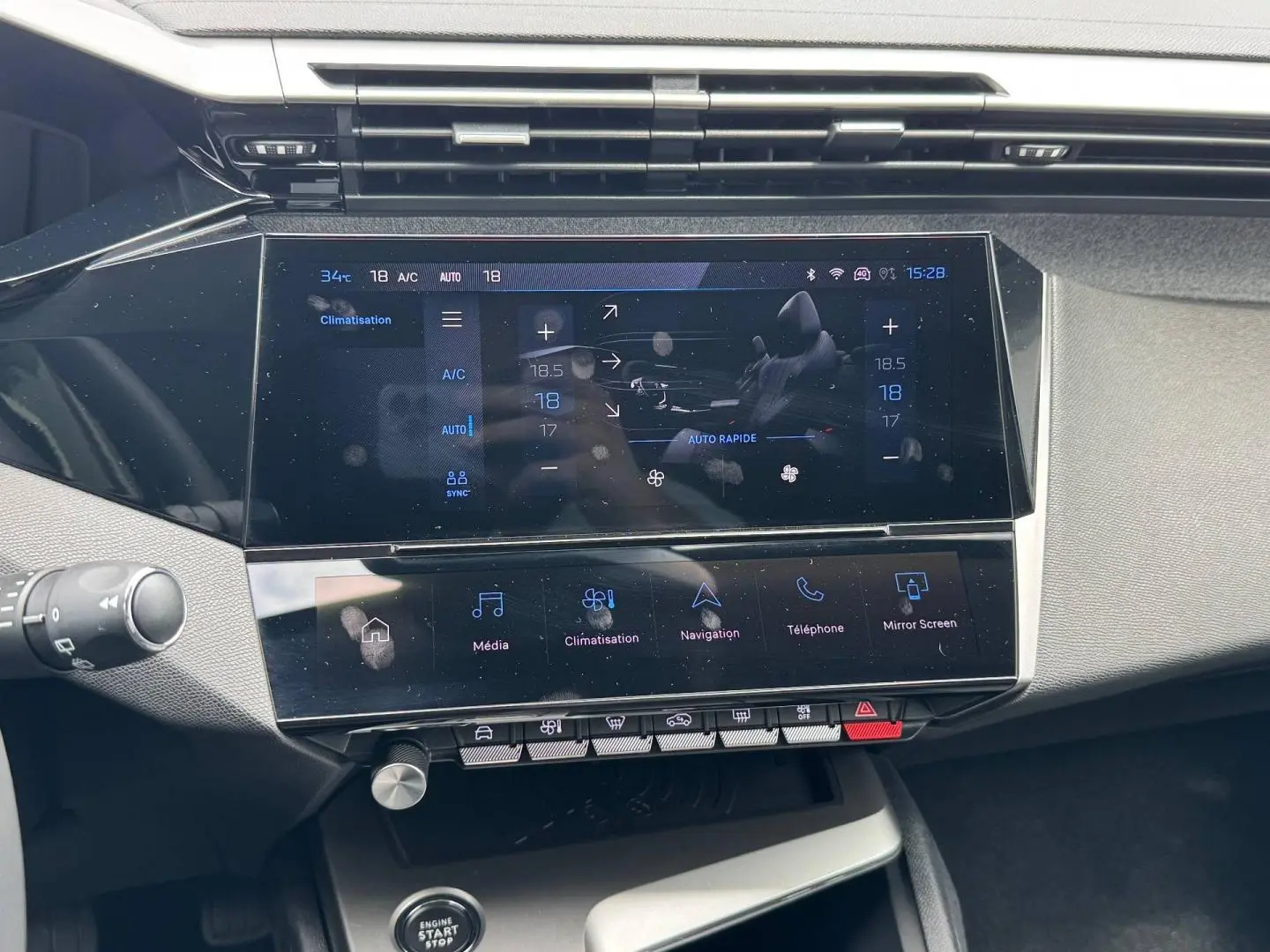 Vue rapprochée de la console centrale tactile noire du Peugeot 308 2025, affichant les commandes de climatisation et multimédia.