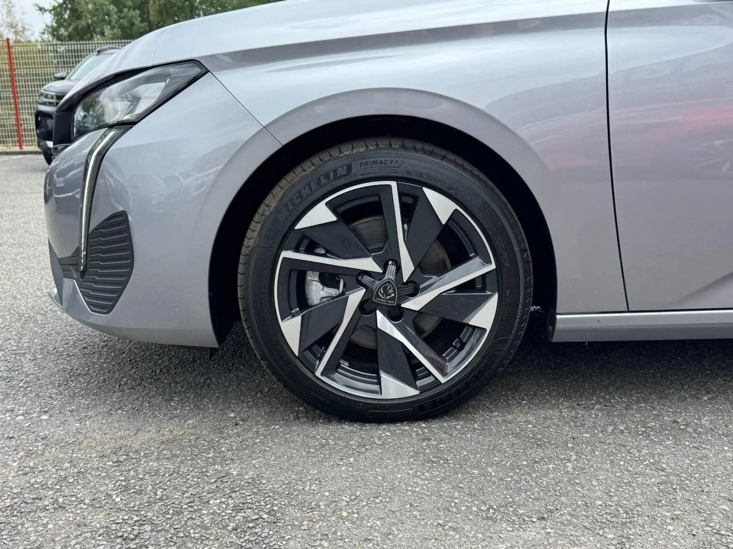 Gros plan sur la roue avant gauche d’une Peugeot 308 gris Artense 2025 avec jante alu au design moderne.