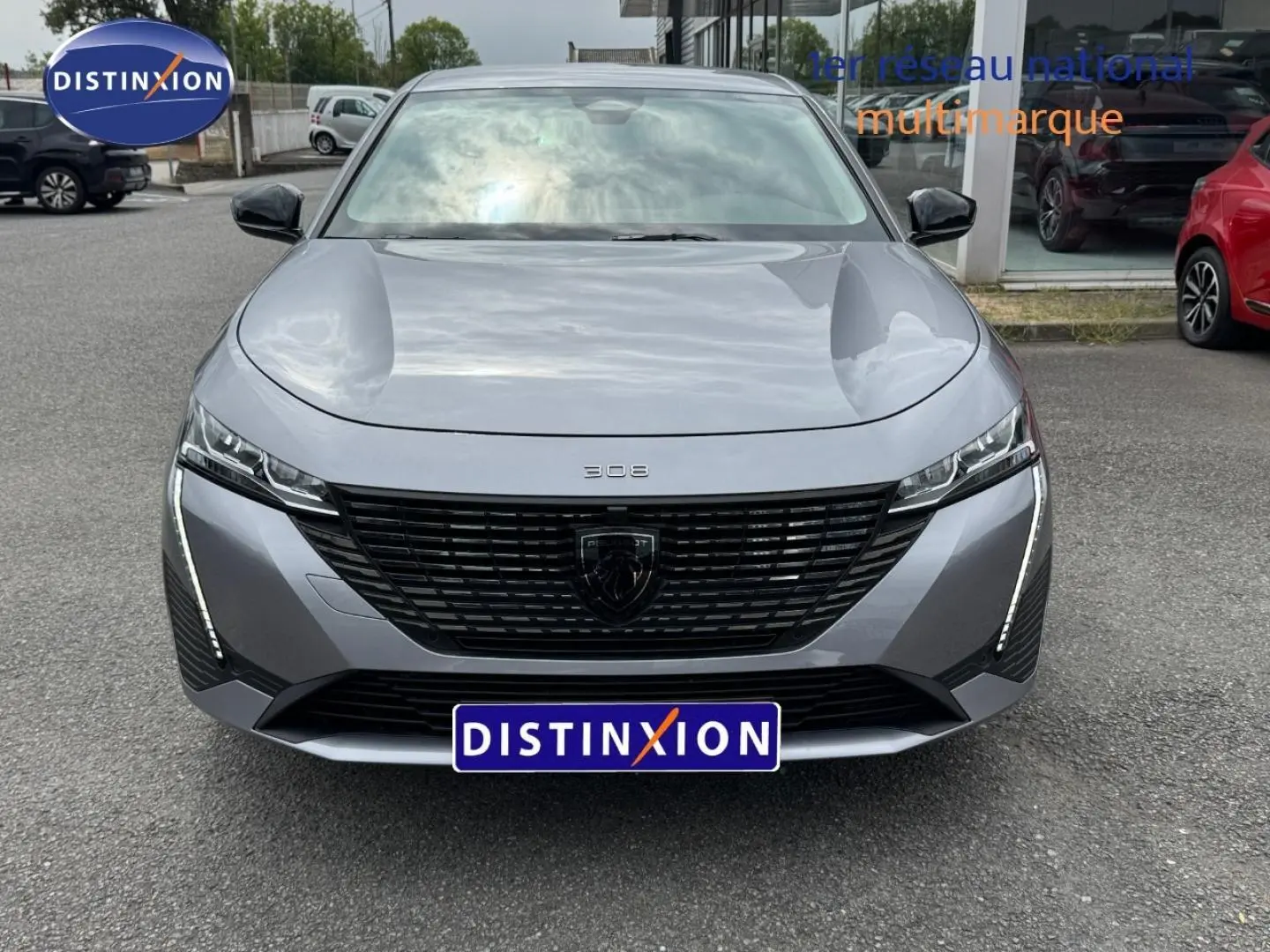 Vue avant frontale de la Peugeot 308 gris Artense avec calandre noire et feux LED verticaux distinctifs.