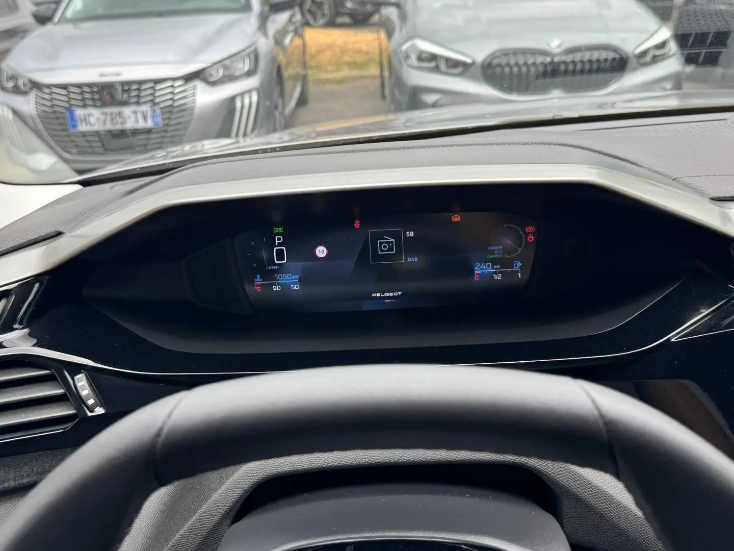 Vue intérieure du tableau de bord numérique de la Peugeot 308 gris Artense, affichant les informations de conduite.