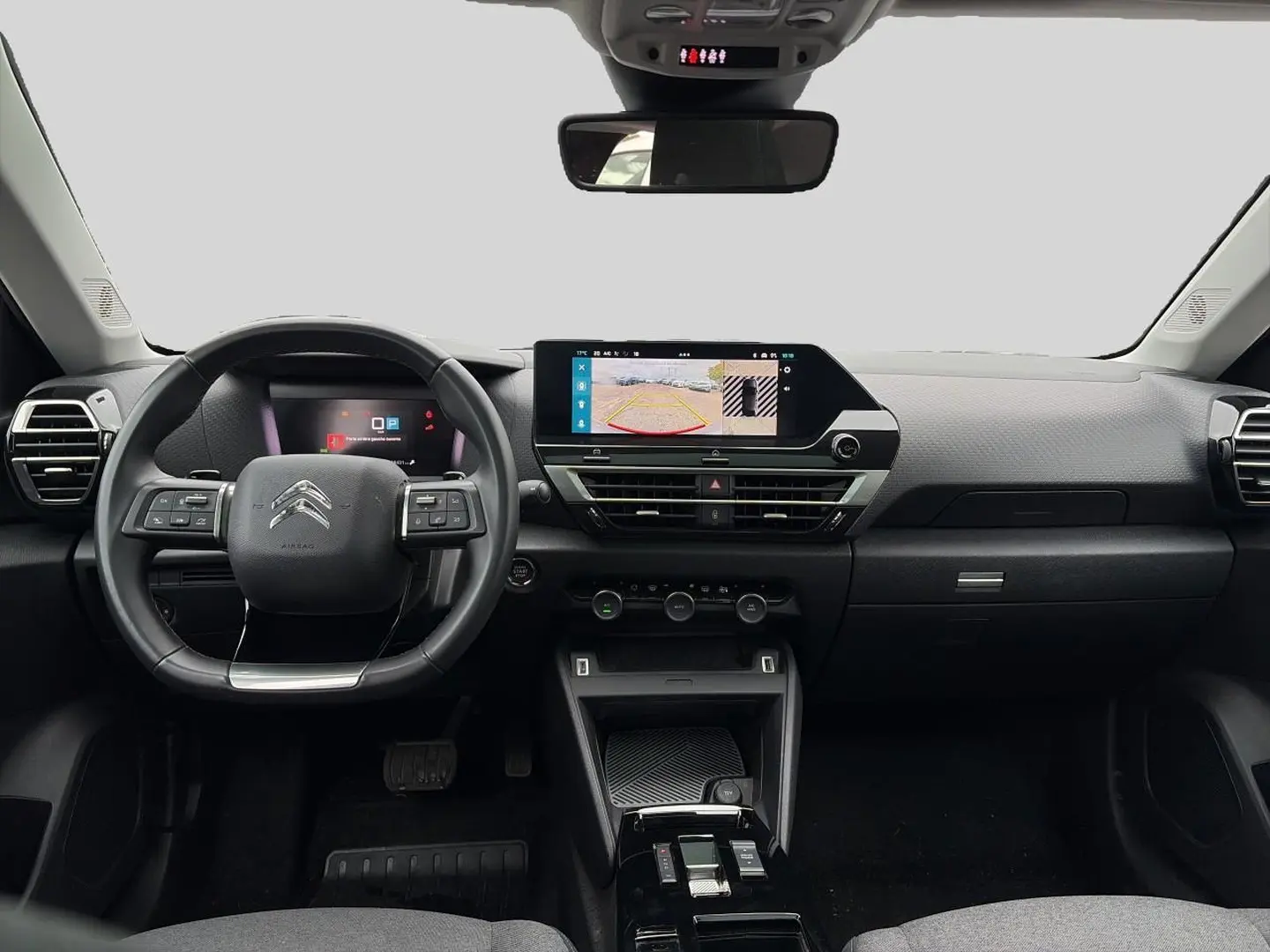 Vue frontale de l'intérieur gris du Citroën C4 2024 avec volant cuir, écran tactile et affichage caméra de recul.