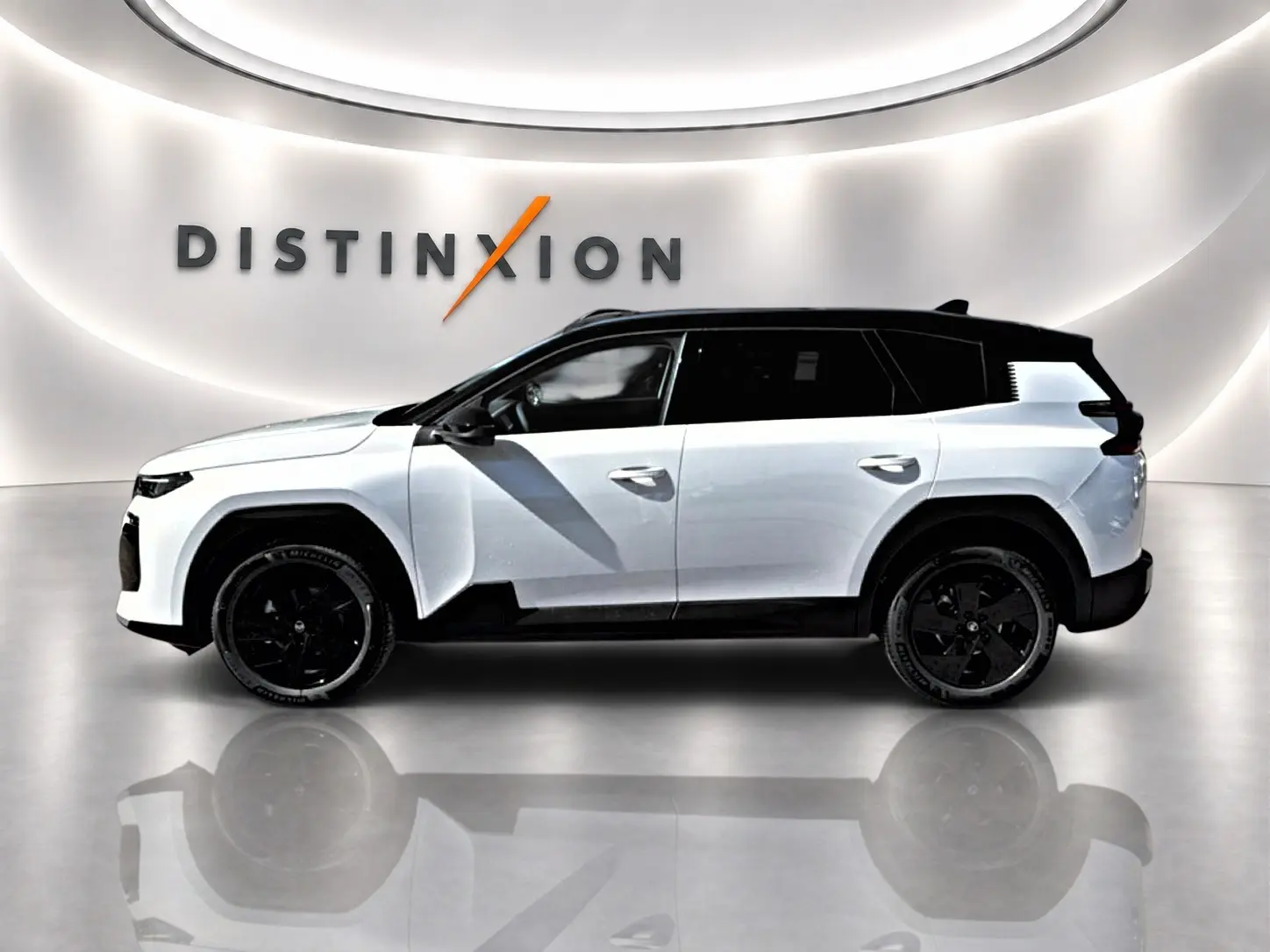 Profil droit du Citroën C5 Aircross blanc à toit noir avec jantes alliage noires dans un showroom lumineux.