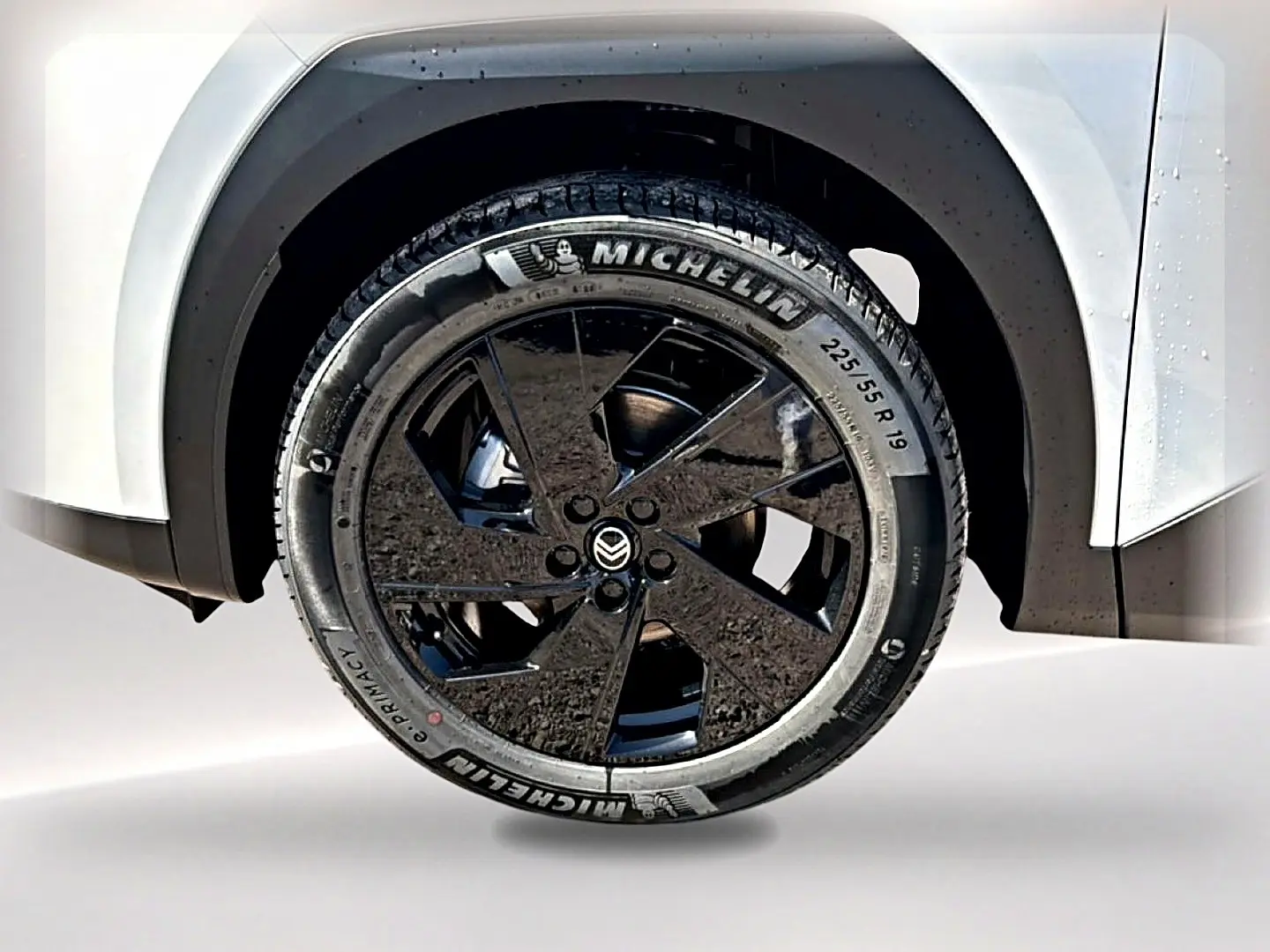 Gros plan sur la roue arrière droite noire et jante alliage 19 pouces du Citroën C5 Aircross blanc et noir.