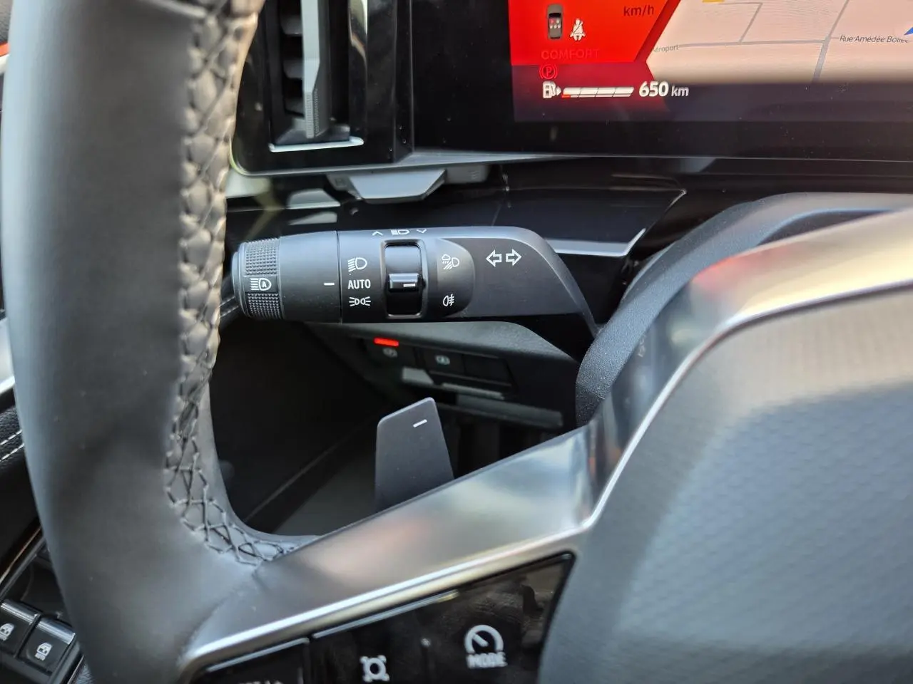 Gros plan sur la manette de clignotant et commandes d’éclairage côté gauche du tableau de bord du Renault Austral blanc nacré.