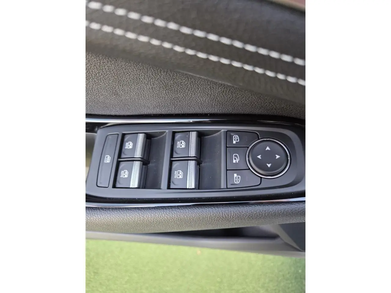 Gros plan sur les commandes des vitres et rétroviseurs côté gauche du Renault Austral E-Tech blanc nacré.