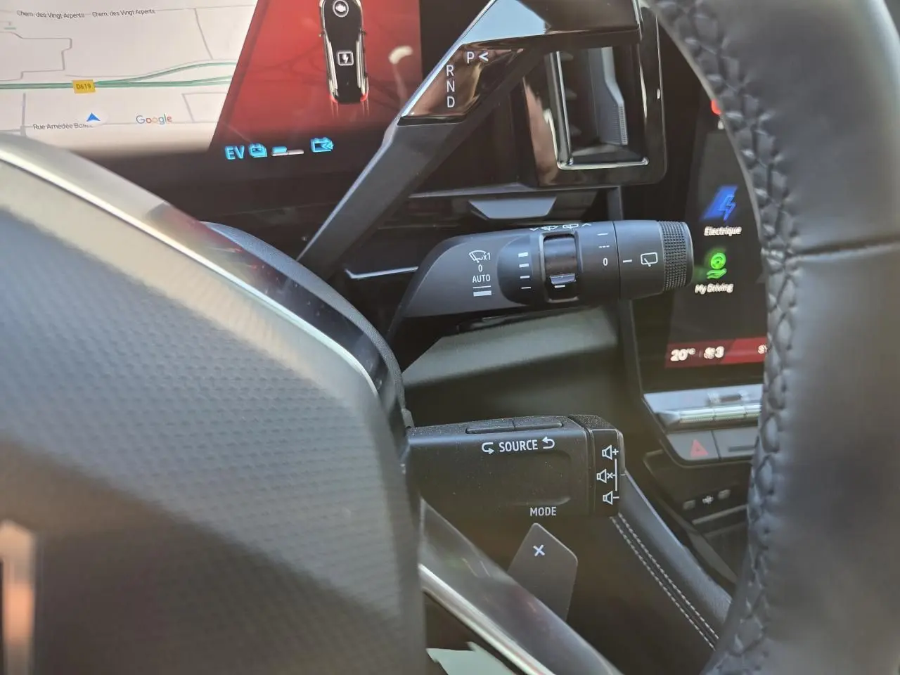 Vue rapprochée du volant et des commandes du Renault Austral E-Tech blanc nacré avec écran tactile et levier de vitesses.