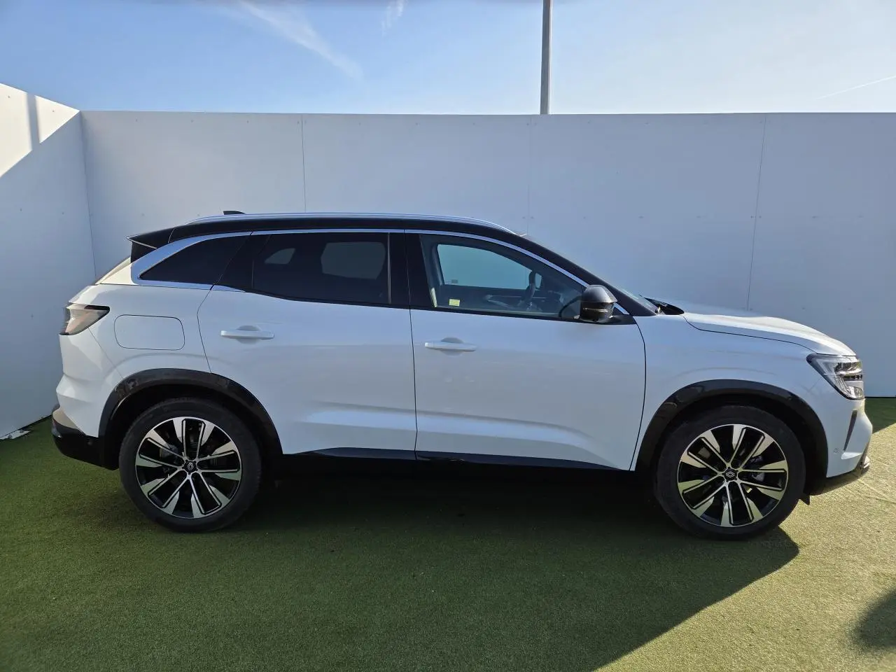 Renault Austral E-Tech blanc nacré avec toit noir, vue de profil côté gauche, jantes alliage noires diamantées.