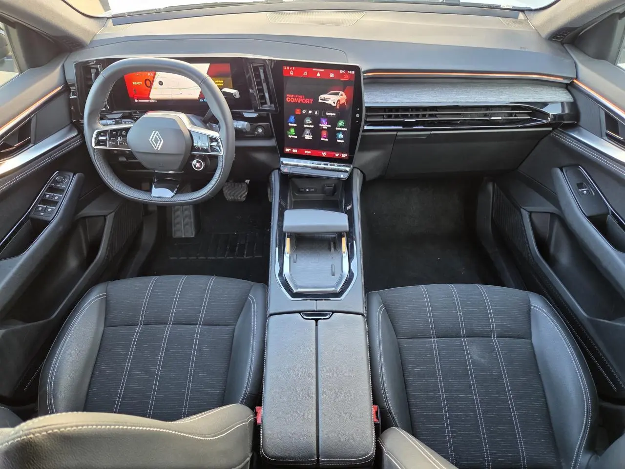 Vue intérieure avant de la Renault Austral E-Tech, tableau de bord moderne avec écran tactile vertical et sièges noirs.