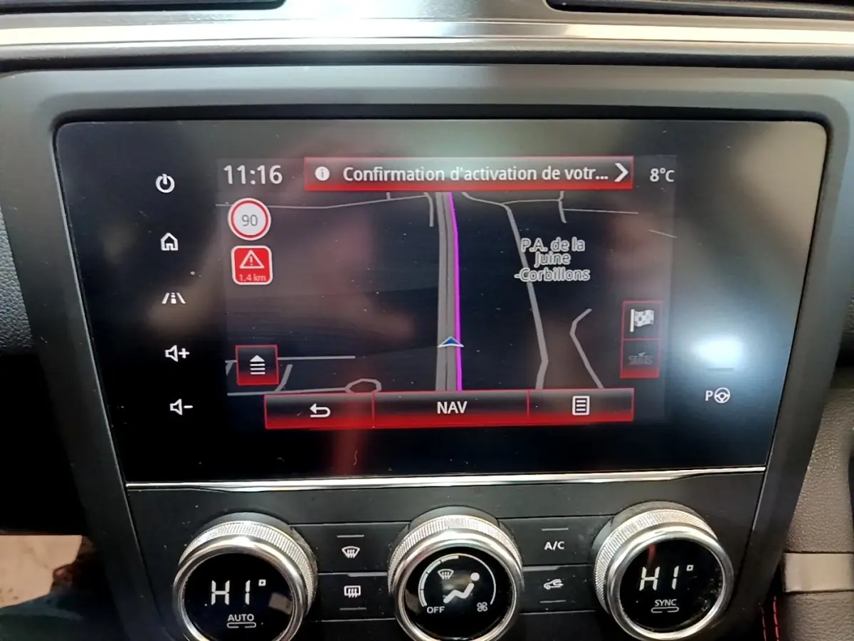 Gros plan sur l'écran tactile central du tableau de bord du Renault Kadjar rouge, affichant la navigation GPS.