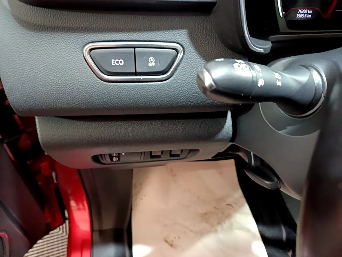 Détail intérieur côté gauche du tableau de bord du Renault Kadjar rouge, avec boutons ECO et commande au volant visible.