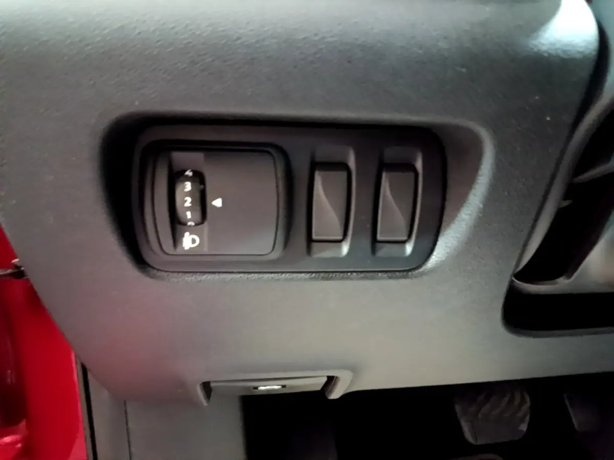 Détail du tableau de bord côté gauche avec commandes de réglage des phares sur Renault Kadjar rouge 2019.