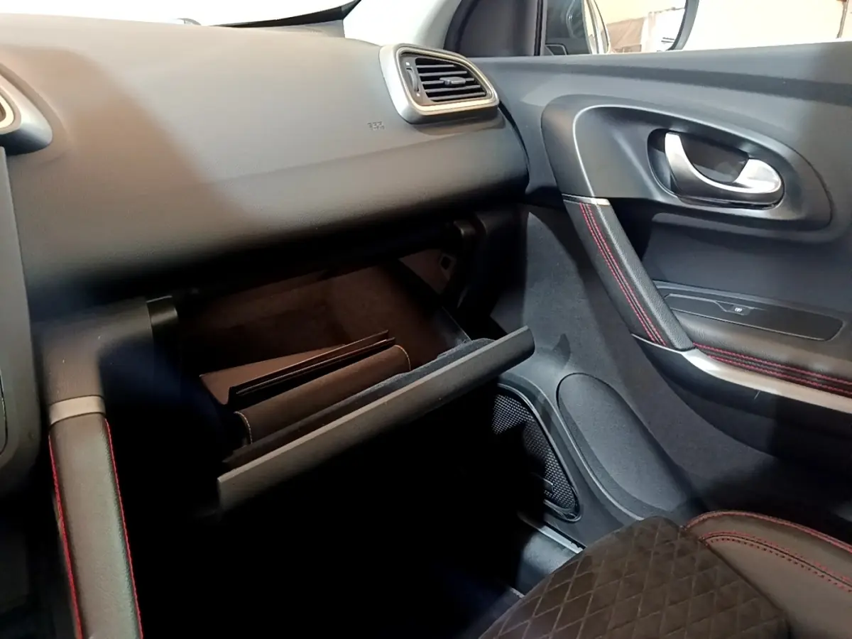 Intérieur côté passager du Renault Kadjar rouge 2019, avec boîte à gants ouverte et surpiqûres rouges sur la porte.