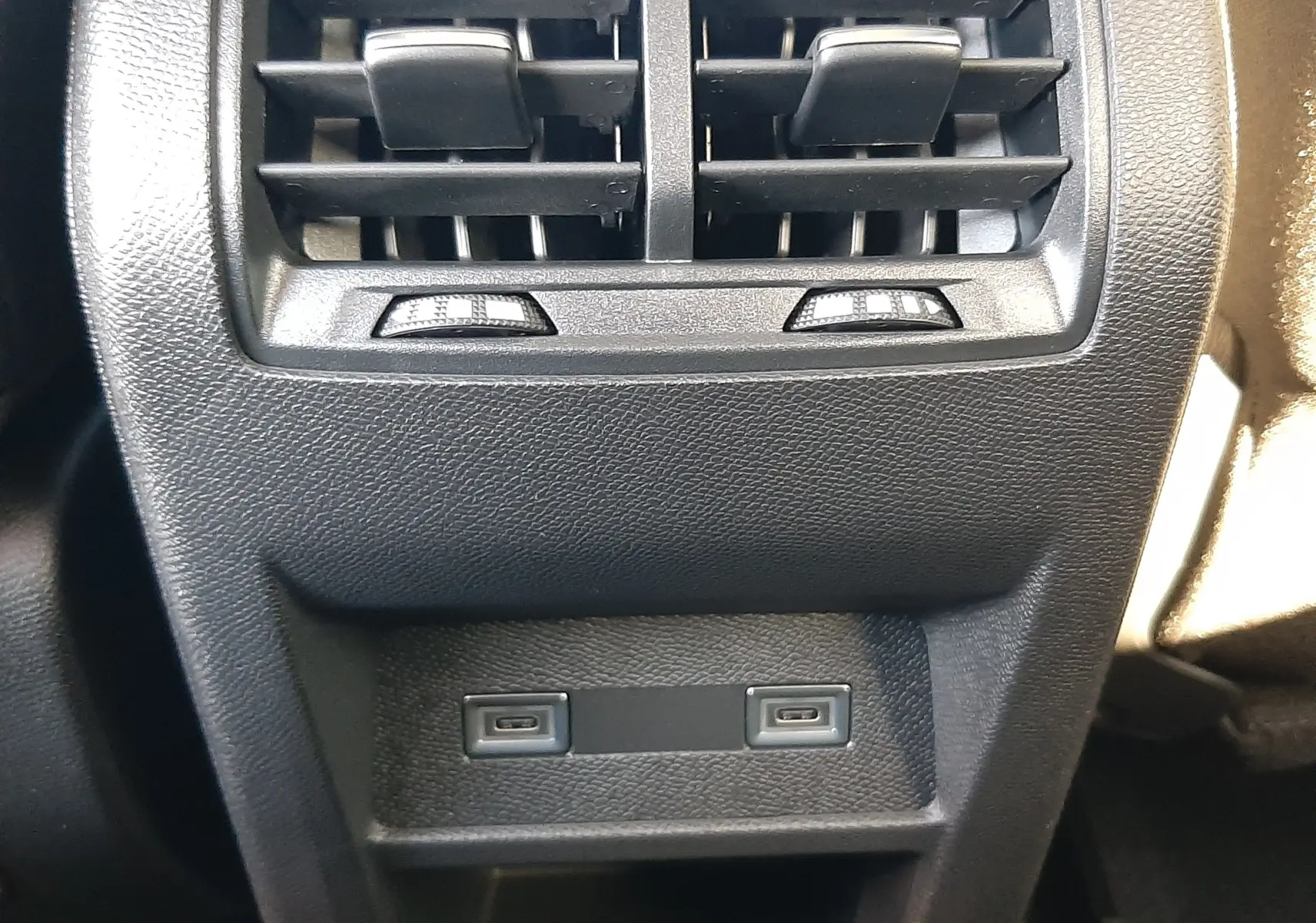 Détail des aérateurs arrière et ports USB-C sur console centrale intérieure d'une Peugeot 308 Bleu Obsession 2025.