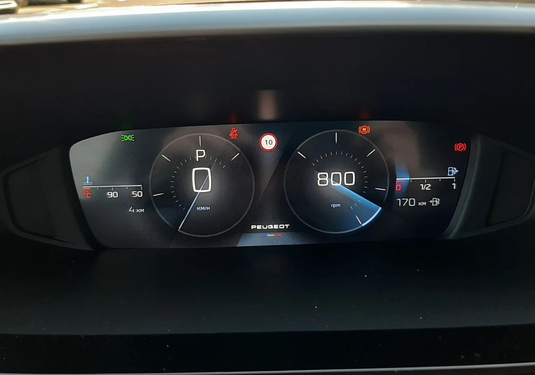 Vue rapprochée du tableau de bord numérique de la Peugeot 308 Bleu Obsession, affichant vitesse, régime et autonomie.