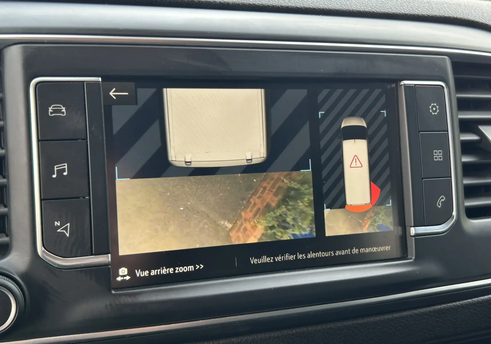 Écran tactile intérieur montrant la caméra de recul et l’alerte de proximité du tableau de bord d’un Opel Vivaro Combi noir.