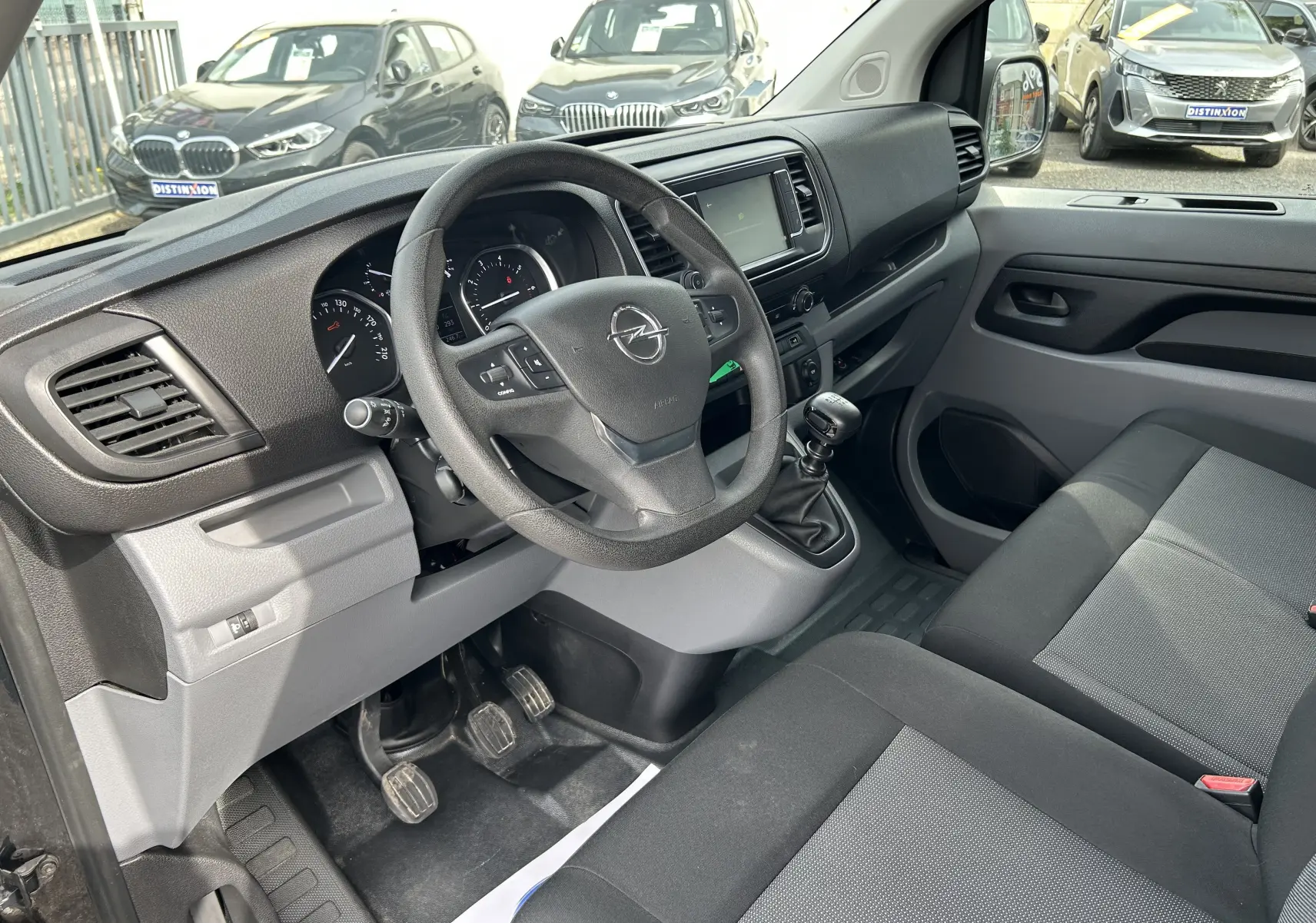 Vue intérieure côté conducteur de l'Opel Vivaro Combi noir 2022, volant multifonction et boîte manuelle visible.