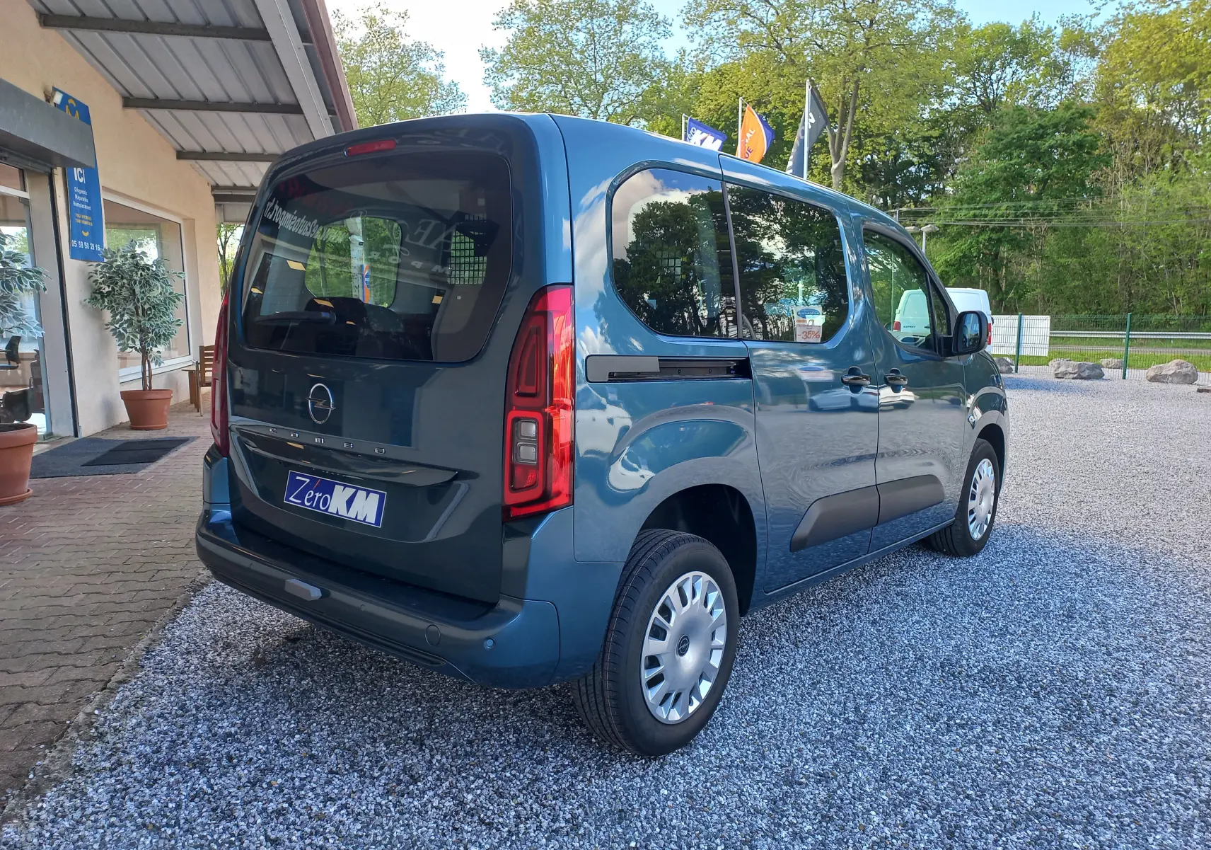 Vue 3/4 arrière droite d’un Opel Combo Life bleu Kiama 2025 avec vitres teintées et porte latérale coulissante.