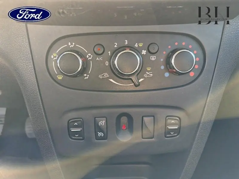 Tableau de bord de Dacia Sandero 2016 montrant les commandes de climatisation manuelle et boutons de réglage, en noir nacré.