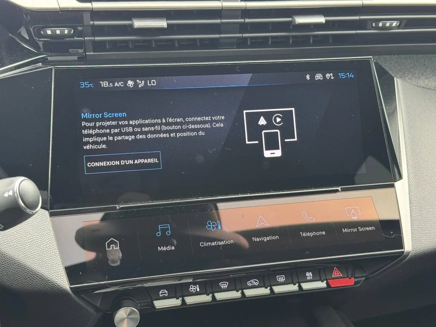 Écran tactile central en gros plan du tableau de bord de la Peugeot 308 1.2 Hybrid bleu, affichant le menu Mirror Screen.