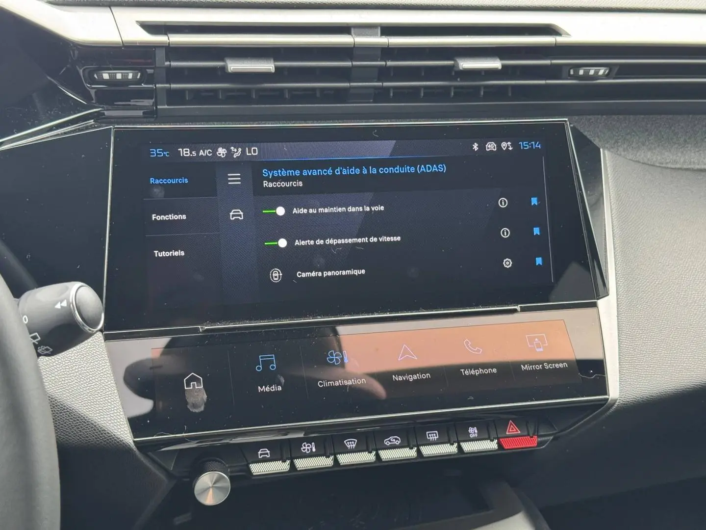 Vue rapprochée de l'écran tactile central du tableau de bord de la Peugeot 308 1.2 Hybrid 145ch Allure, affichant les aides à la conduite.