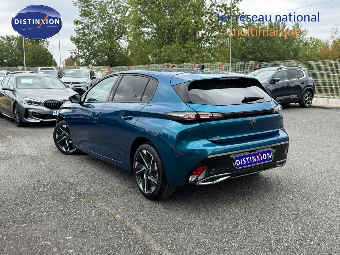 Vue 3/4 arrière droite d'une Peugeot 308 bleu Obsession avec feux arrière LED et jantes alliage modernes.