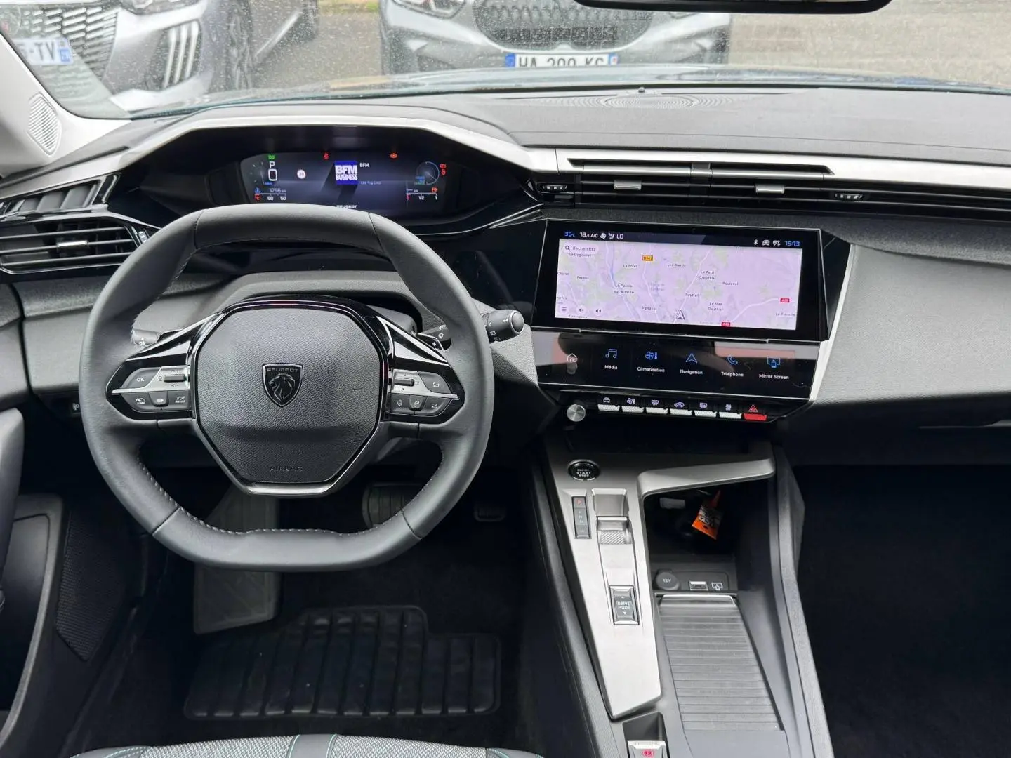 Vue intérieure centrée sur le volant et l’écran tactile du tableau de bord de la Peugeot 308 1.2 Hybrid 2025.