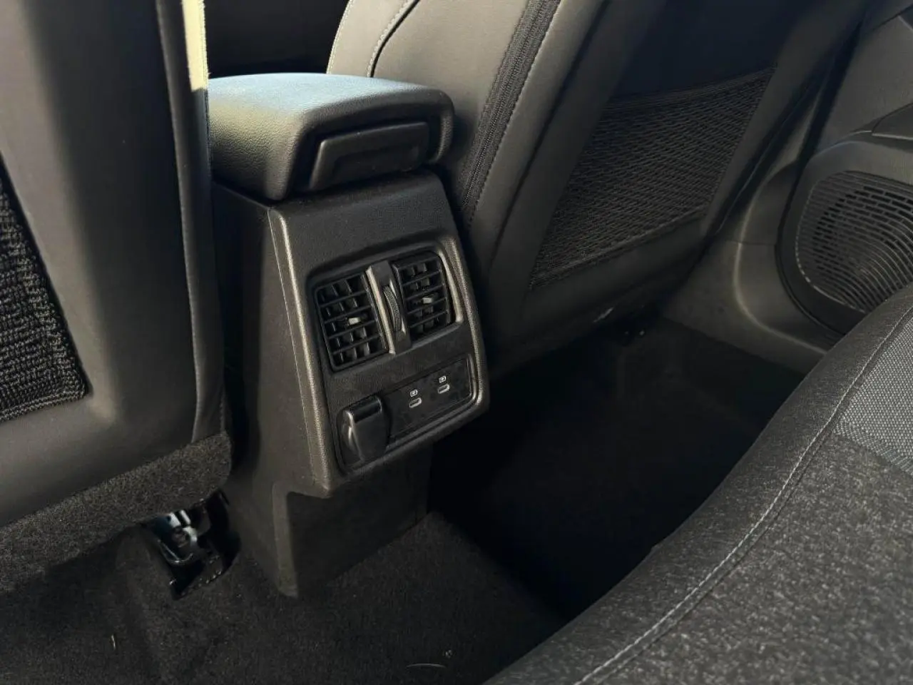Vue rapprochée de la console centrale arrière avec prises USB C et aération dans le Renault Captur II rouge flamme.