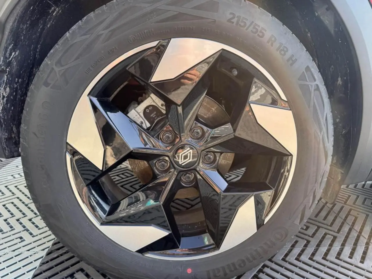 Gros plan sur la jante aluminium 18 pouces noire et argentée du Renault Captur II Rouge Flamme toit noir.