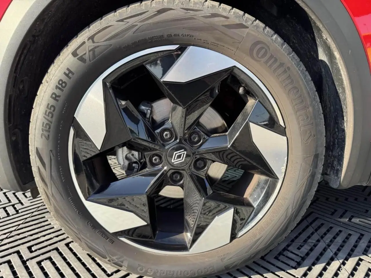 Gros plan sur la roue arrière droite du Renault Captur II rouge flamme avec jante aluminium 18 pouces.