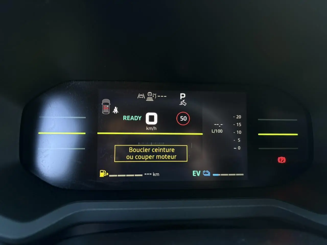 Tableau de bord digital du Dacia Duster gris, affichant la vitesse à 0 km/h et un message de sécurité ceinture.